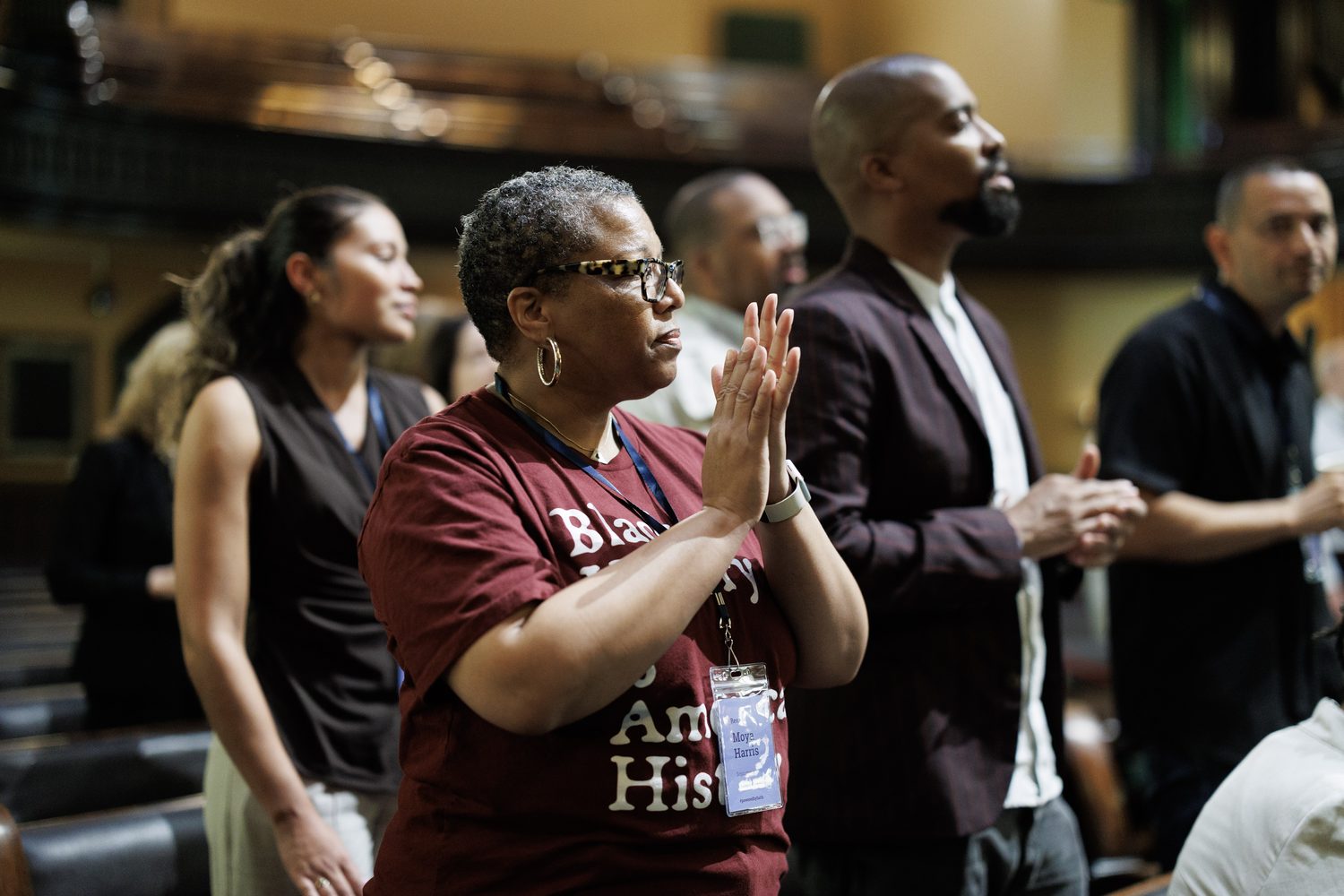 Participants standing and applauding during the convening